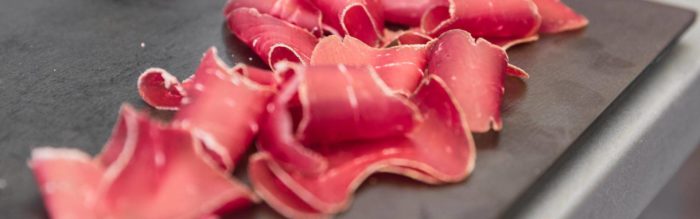 La Bresaola è il salume valtellinese che si ottiene dalla lavorazione della carne di manzo cruda e stagionata