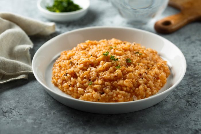 ricetta del risotto al pomodoro con piselli e prosciutto cotto