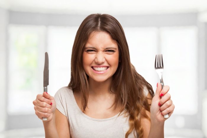 donna che mangia bresaola per la salute di capelli, ossa, denti e unghie