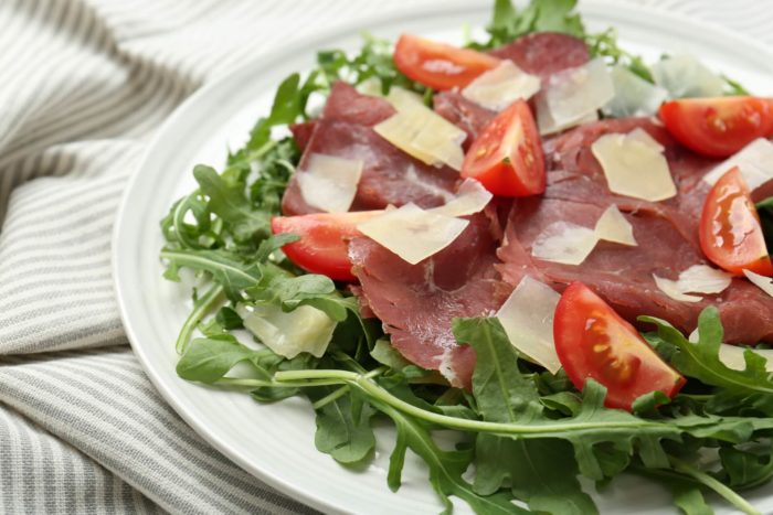 piatto estivo con la bresaola: insalata leggera con rucola, grana, pomodorini e bresaola