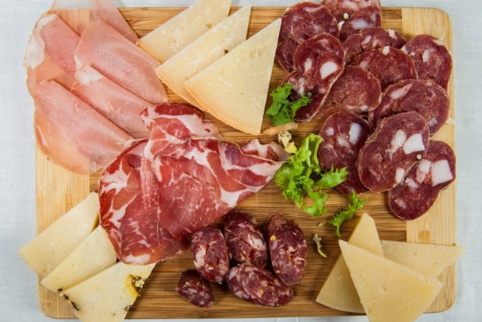 abbinamenti tra salumi e formaggi in un tagliere di affettati con prosciutto, salame e altre specialità italiane