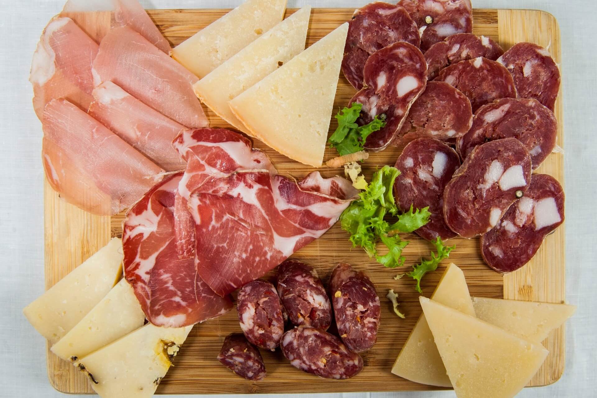 abbinamenti tra salumi e formaggi in un tagliere di affettati con prosciutto, salame e altre specialità italiane